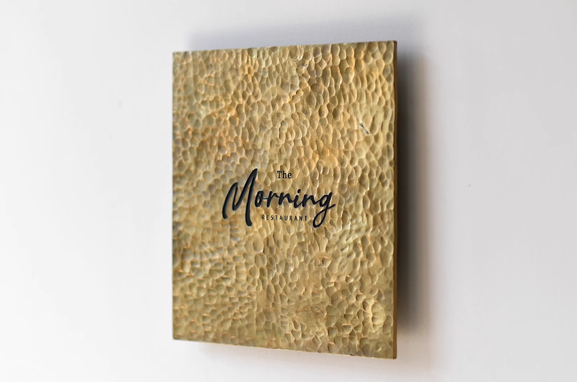 Handcrafted hammered brass business sign for restaurant entrance
