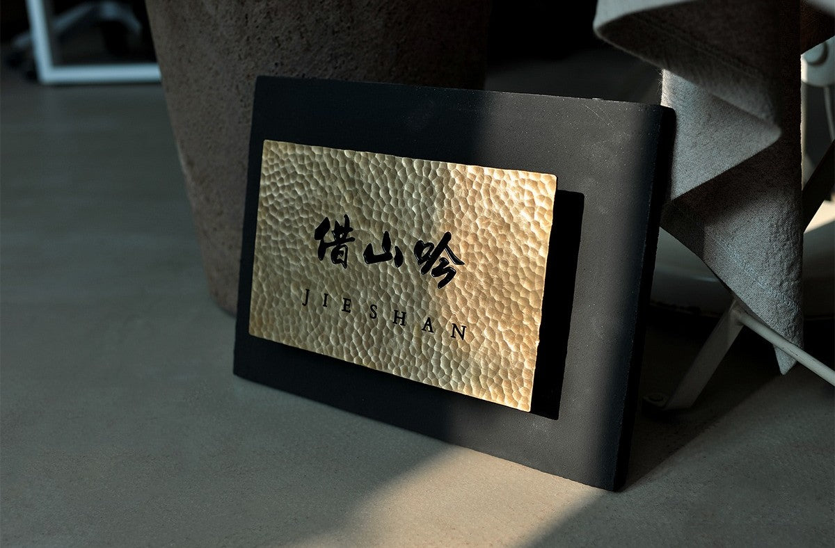 Custom Hammered Brass Sign on Dark Stainless Steel Box - Side Profile View.