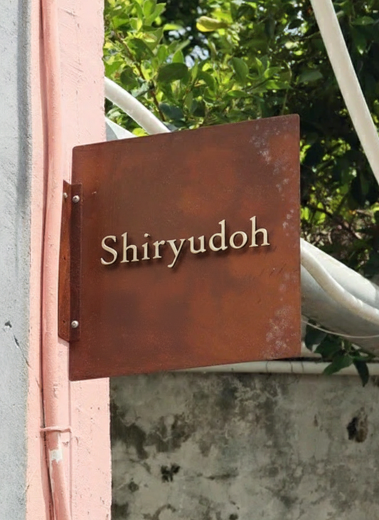 Side mounted rusted iron blade sign with 3D raised stainless steel letters