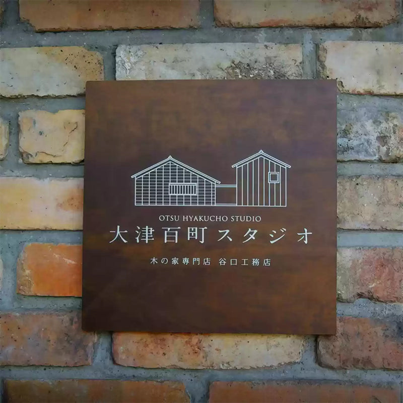 Industrial Rusted Iron Sign with White UV Printed Logo on Brick Wall.