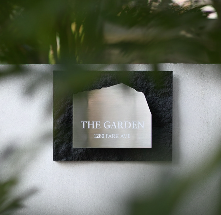 Outdoor Garden Address Plaque installed on white wall with greenery.