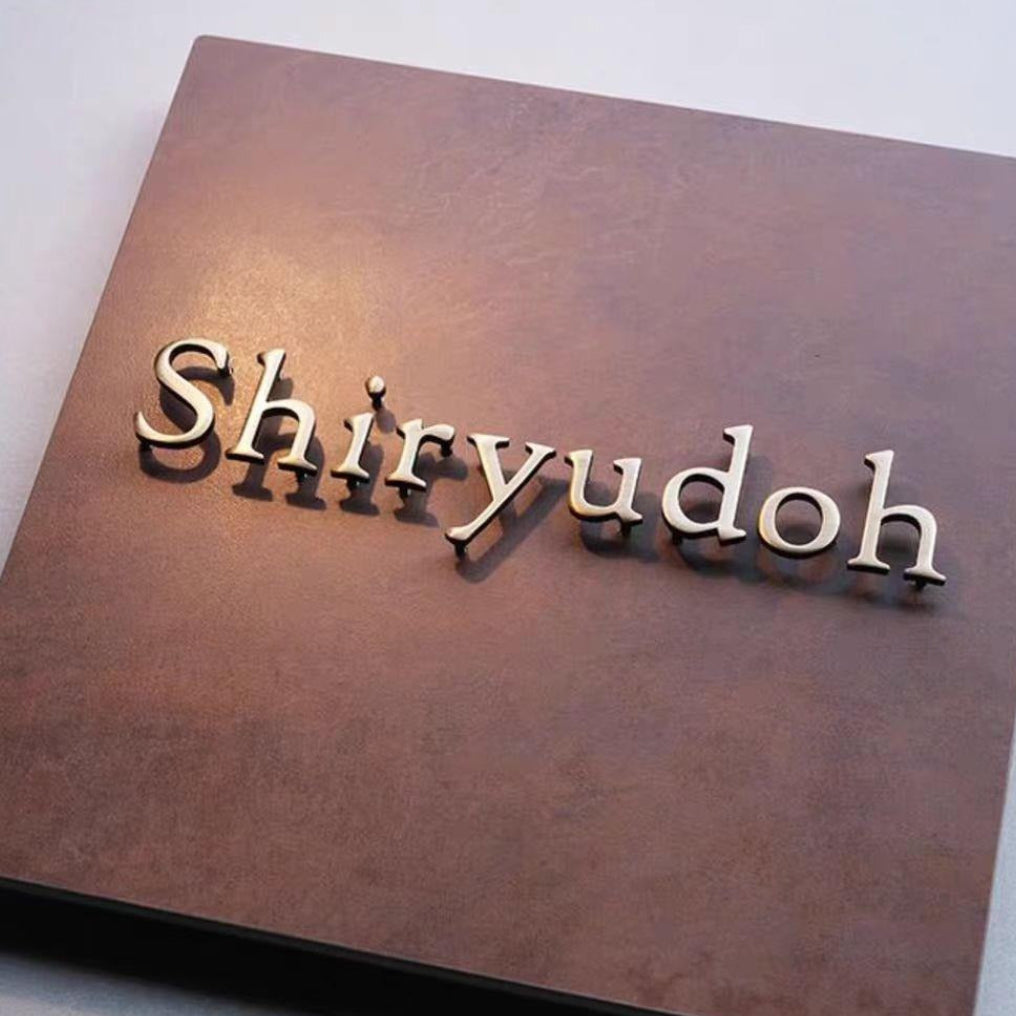 Close-up of 3D Raised Stainless Steel Letters on Rusted Iron Patina