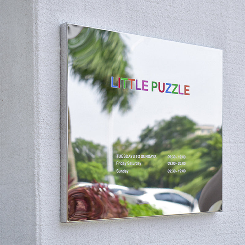 Close-up of a mirror finish stainless steel plaque with vibrant UV printed colorful logo ("LITTLE PUZZLE"), showcasing high-definition color reproduction