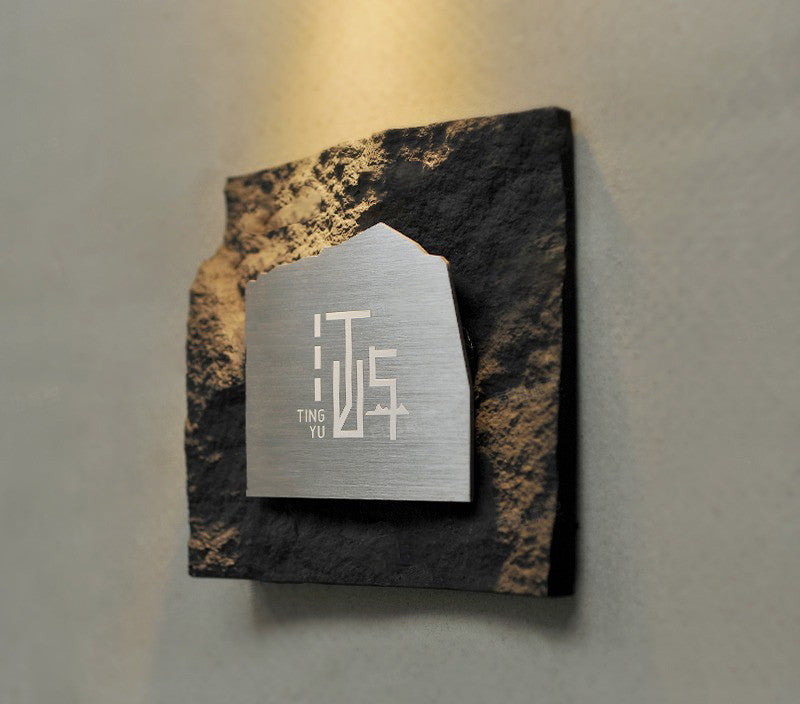 Wall mounted stone signage showing shadow depth and floating effect.